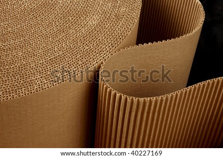 close up shot of corrugated packing material uncurling on black background