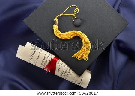 Cap, tassel and diploma shot on blue graduation gown