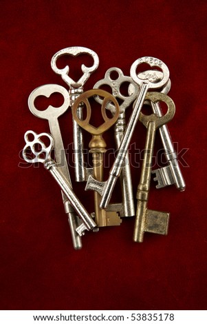Closeup shot of group of overlapping skeleton keys shot on red suede