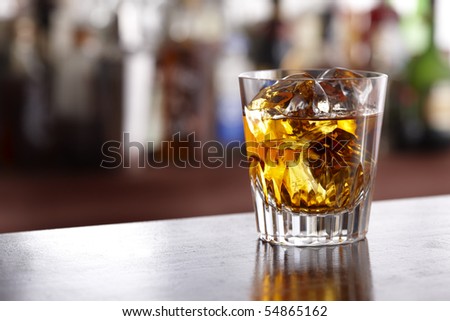 Glass of scotch whiskey shot in bar with room for copy