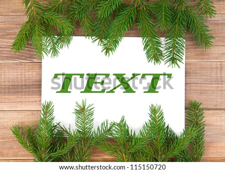 branches from a fir-tree and message on wooden background