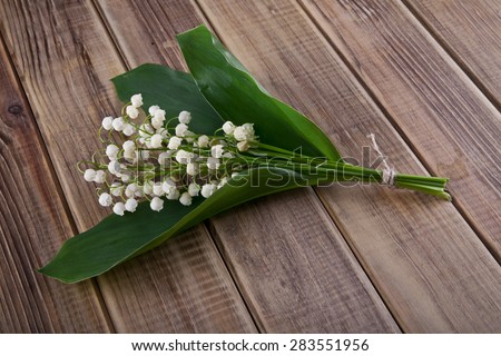 flowers of lilies of the valley on wooden background