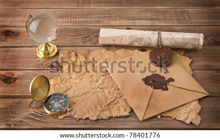 letters, map, compass and globe on a wooden table