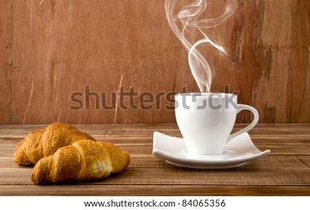 croissants and cup of coffee on a wooden background