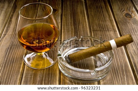 alcohol and smoking a cigar on the wooden background
