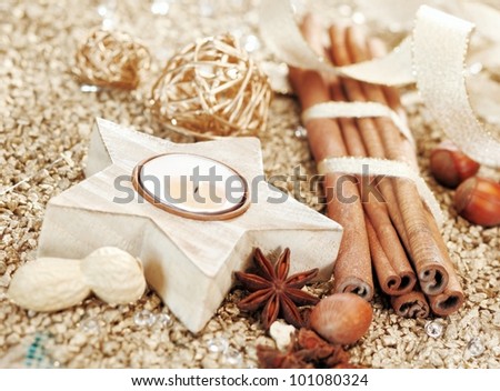 Christmas decorative background with a star shaped candle and mixture of dried spices and nuts