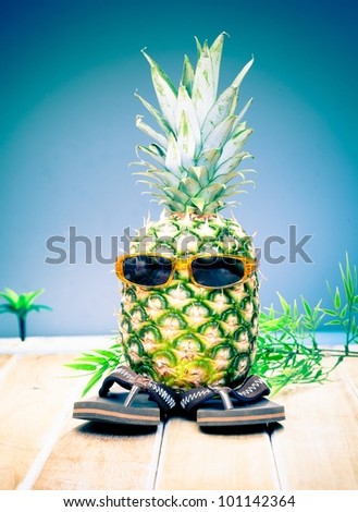 Comical character of a cool dude pineapple in his trendy sunglasses and slip slops out enjoying the tropical sunshine