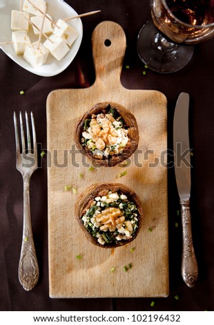 Filled mushroom with cheese on wooden breadboard
