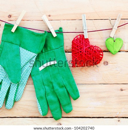 Gardening Hand Gloves. The beautyful feeling of gardening. Some hearts and gardening hand gloves on a wooden background. Square Format. For more see my portofolio