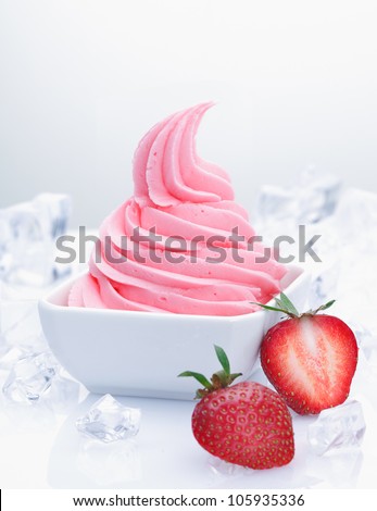 Frozen strawberry yogurt with with fresh fruits and flavored creamy yoghurt. With crushed ice and cubes on white background
