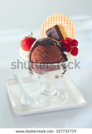 Rich mouth watering chocolate ice-cream topped with melted chocolate and served garnished with squares of slab chocolate, berries and a wafer
