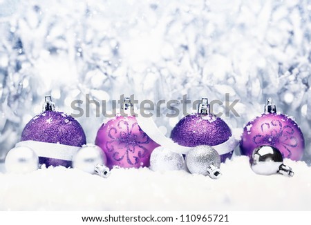 Decorative Christmas greeting with pretty purple baubles with festive silver bow and bokeh