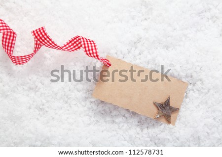 Empty place card or gift card for christmas and festive winter concepts. On white snow background.