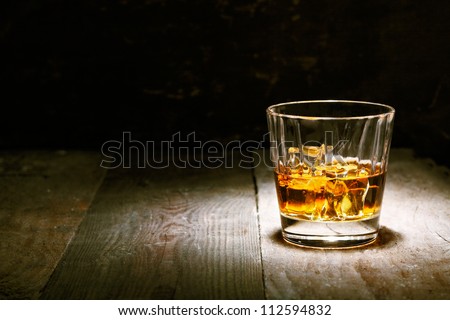 Scotch On Wooden Background With Copyspace. An Old And Vintage Countertop With Highlight And A Glass Of Hard Liquor