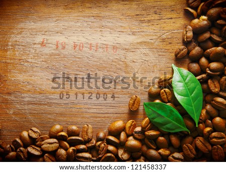 Coffee bean border on an old wood surface with stamped numbers from a shipment of coffee beans with two green leaves