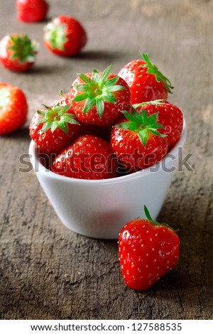 Small White China Bowl Filled With Succulent Juicy Fresh Ripe Red Strawberries On An Old Wooden Textured Table Top