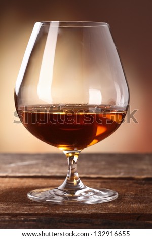 Glowing golden brown cognac served in a snifter as a luxury after dinner beverage