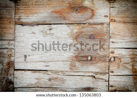 Weathered wooden planks texture with cracks, joins and nails in old wood cladding in a building