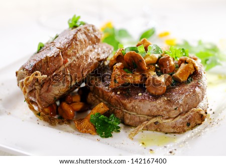 Gourmet thick juicy fillet steak medallions grilled to perfection and served topped with fried wild mushrooms and herbs