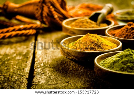 Asian Cuisine With A Low Angle View Of Bowls Of Colourful Spices With Focus To A Bowl Of Turmeric Based Curry Powder