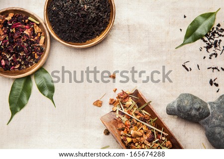 Close-up of medicinal and aromatic plants, leaves and an Asian ancient statue, symbol of traditional Chinese medicine