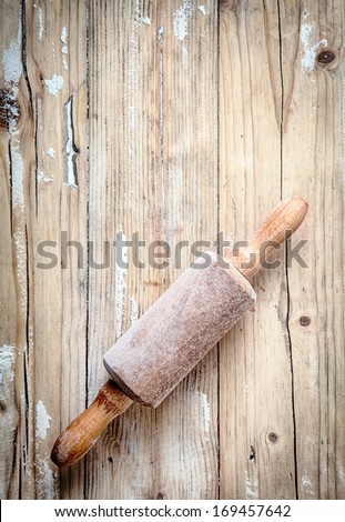 Old Small Wooden Rolling Pin Covered In A Thin Layer Of Flour From Baking And Rolling Dough Lying On A Wooden Table In A Country Kitchen, Overhead, View With Copyspace