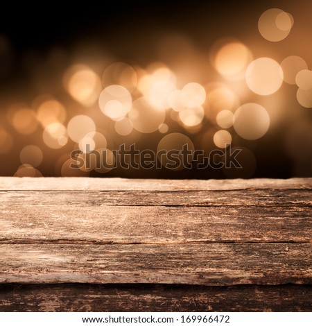 Old Weathered Wooden Board Or Rustic Table Top With A Sparkling Bokeh Of Golden Party Lights In The Background