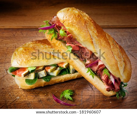 Two freshly baked crisp crusty baguettes filled with figs, spinach and blue cheese and gourmet cold roast beef for a delicious takeaway or savory lunch