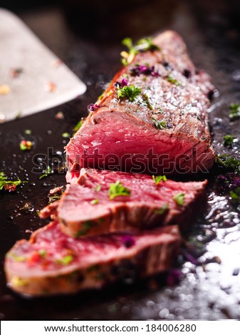 Gourmet sliced rare roast beef seasoned with chopped fresh herbs ready to be served for dinner