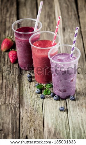 Choice of three delicious berry smoothies blended with yogurt or ice cream with fresh strawberries and blueberries, high angle view