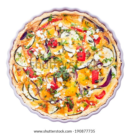 Overhead view of a delicious savory tart with clipping path in a decorative fluted pie dish with eggplant, cheese, egg, herbs and peppers for a tasty vegetarian meal