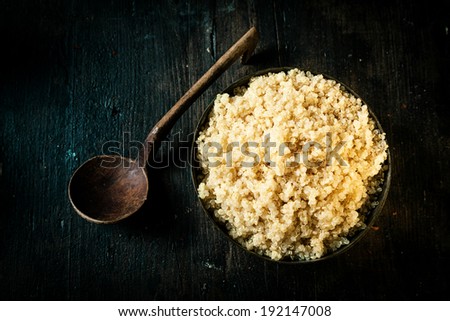 Overhead view of a bowl of delicious healthy quinoa made from the seeds of the goosefoot plant and classed as a superfood for its high protein and nutritional value on a dark background