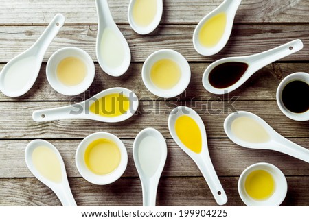 Several soup spoons and sauce dishes arranged randomly on wooden surface
