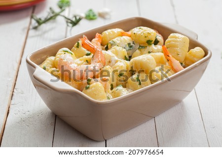 Tasty Italian seafood cuisine with grilled pink prawns in gnocchi pasta, or semolina dumplings, served in a casserole seasoned with fresh herbs