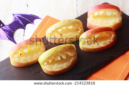 Scary Halloween apples with cutout teeth in an open mouth for a healthy fun favor for young kids trick-or-treating