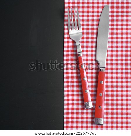 Close up Kitchen Utensils on Red White Checkered Cloth at Black Table.