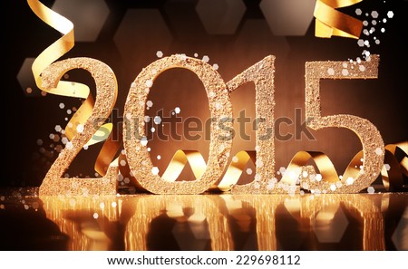 Elegant gold 2015 New Year background with textured golden numbers and twirled gold ribbon on a reflective dark brown surface for your seasonal greeting or invitation