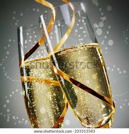 Close up Golden Wine on Flute Glasses with Gold Laces on Abstract Gray Background. A New Years Day Concept Design.