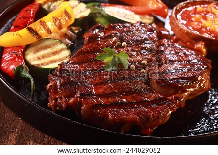 Close Up of Grilled Steak on Cast Iron Pan with Grilled Vegetables on the Side