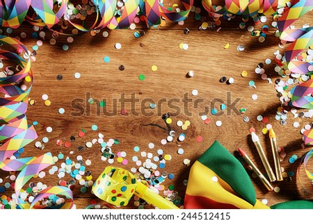 Close up Wooden Table with Festival Props - Confetti, Paper Streamers, Whistle, Ribbon and Pencil. Emphasizing Copy Space.