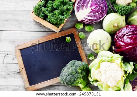 Close up Fresh Salad Vegetables from the Farm on Wooden Table with Black Chalkboard. Emphasizing Copy Space.