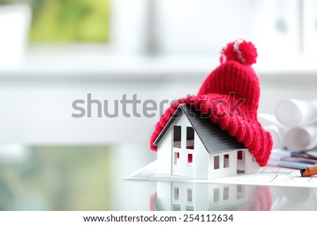 Close up Conceptual of Insulation Symbol House with Red Bonnet in office burreau.