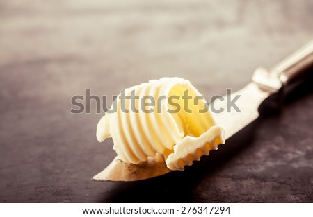 Close up Butter on a Knife for Bread Filling, Placed on Top of a Vintage Wooden Table