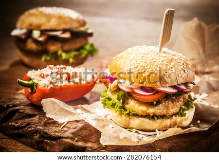 Vegetarian Couscous Burgers with Fresh Toppings and Sesame Seed Roll Accompanied by Stuffed Pepper on Brown Paper Wrapper