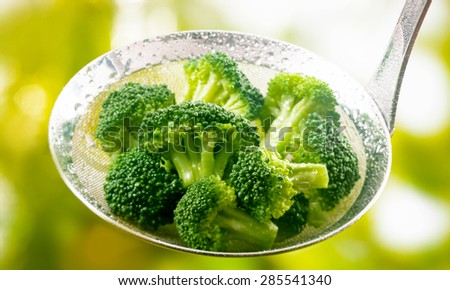 Ladle full of steamed fresh young broccoli florets rich in vitamin c and dietary fiber for a healthy diet