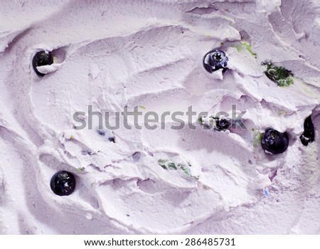 Background texture of creamy blueberry ice-cream with whole fresh fruit in a swirling pattern for a summer treat