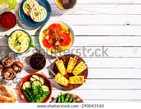 High Angle View of Vegetarian Mediterranean Meal of Grilled Fruit and Vegetables Spread Out on White Wooden Picnic Table with Copy Space