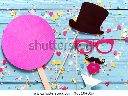 Party fun with photo booth accessories arranged as a gent in a top hat with a mustache sipping cocktails with a magenta circle with copy space alongside for your invitation or greeting