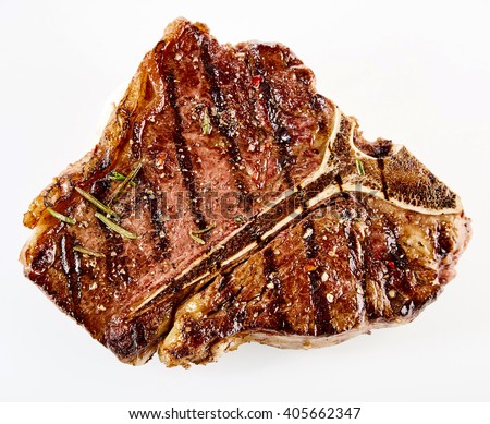 Juicy thick grilled T-bone beef steak seasoned with rosemary fresh of the summer BBQ viewed from above in a close up view over white