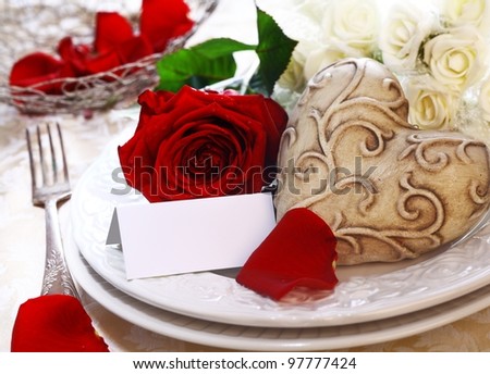 Wedding Place Setting with a place card, red and white roses and a heart